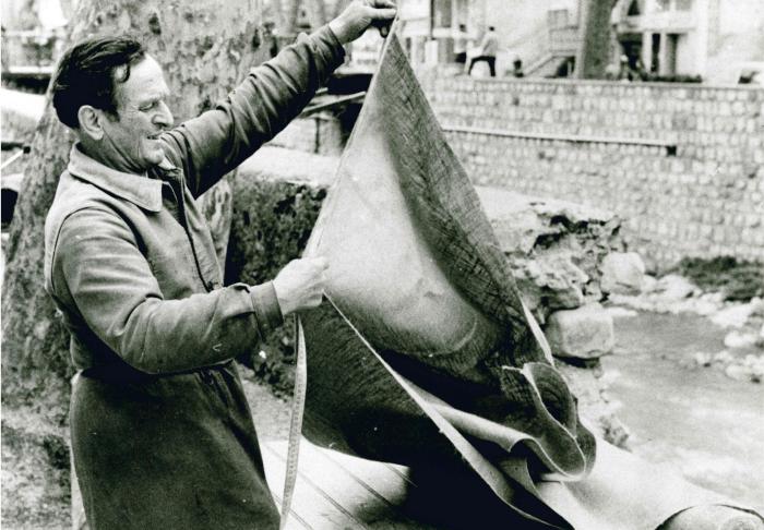 Jean Ros fabriquant un bât : découpage de la toile des coussinets supérieurs.